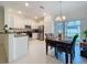 Bright kitchen featuring stainless steel appliances, granite countertops, and white cabinets near the dining area at 36495 Garden Wall Way, Zephyrhills, FL 33541
