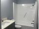 Bathroom features a shower with safety bar and a gray vanity, showcasing its practical and stylish design at 5521 80Th Street North # 306, St Petersburg, FL 33709