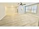 A spacious living room featuring sleek wood-look floors and a large window with shutter style blinds at 5521 80Th Street North # 306, St Petersburg, FL 33709