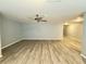 An expansive living room with new wood-look flooring, light gray walls, and a modern ceiling fan at 5521 80Th Street North # 306, St Petersburg, FL 33709