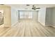 An open-concept living room with wood-look flooring, a ceiling fan, and a pass-through to the kitchen at 5521 80Th Street North # 306, St Petersburg, FL 33709