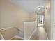 Hallway with wood-look flooring and stairs leading down to a carpeted floor at 116 S Obrien St, Tampa, FL 33609