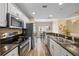 Well-lit kitchen with modern appliances, granite countertops, white cabinets, and a view into dining area at 116 S Obrien St, Tampa, FL 33609
