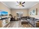 Cozy living room with neutral tones, featuring a large sectional sofa, modern ceiling fan, and entertainment center at 116 S Obrien St, Tampa, FL 33609