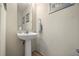 Cozy half-bathroom with a pedestal sink, decorative mirror, and neutral color scheme at 116 S Obrien St, Tampa, FL 33609