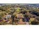 An aerial view of the property featuring lots of trees, a pond, and surrounding neighborhood at 32589 Greenwood Loop, Wesley Chapel, FL 33545