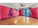 A bedroom with colorful walls, hardwood floors, a ceiling fan, and french doors to the outside at 32589 Greenwood Loop, Wesley Chapel, FL 33545