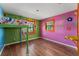 Whimsical bedroom featuring colorful wall paintings, hardwood floors, and a lofted bed at 32589 Greenwood Loop, Wesley Chapel, FL 33545
