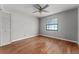A bedroom with gray walls, wood floors, a ceiling fan, and a large window at 32589 Greenwood Loop, Wesley Chapel, FL 33545