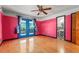 A bedroom with colorful walls, hardwood floors, a ceiling fan, and french doors to the outside at 32589 Greenwood Loop, Wesley Chapel, FL 33545