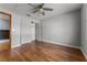 Bright bedroom featuring hardwood floors, a ceiling fan, and a closet at 32589 Greenwood Loop, Wesley Chapel, FL 33545