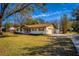 Inviting single-story home showcasing a covered front porch with a swing and well-maintained front yard at 32589 Greenwood Loop, Wesley Chapel, FL 33545