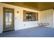 Covered front porch with a decorative door, window with shutters, and a charming swing for relaxing at 32589 Greenwood Loop, Wesley Chapel, FL 33545