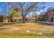 Single story house with a large tree in the middle of the yard, plus a basketball hoop and a long driveway at 32589 Greenwood Loop, Wesley Chapel, FL 33545