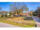 Charming single-story home featuring a large tree and a well-manicured front lawn at 32589 Greenwood Loop, Wesley Chapel, FL 33545