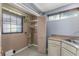 A bright laundry room featuring built in cabinets, a utility sink, and a large window at 32589 Greenwood Loop, Wesley Chapel, FL 33545