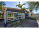 Charming blue home with a brick walkway, complemented by palm trees and lush landscaping at 10952 61St Ave, Seminole, FL 33772