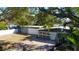 Well-maintained home showcasing a gravel front yard, large garage, and an ample driveway at 10952 61St Ave, Seminole, FL 33772