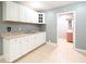 Kitchen features white cabinets, tiled floors, and a doorway leading to a bathroom at 10952 61St Ave, Seminole, FL 33772