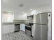 Well-lit kitchen with white cabinets, stainless steel appliances, and stylish wood-look flooring at 10952 61St Ave, Seminole, FL 33772