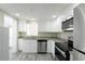 Bright kitchen featuring white cabinets, stainless appliances, granite counters, and wood-look floors at 10952 61St Ave, Seminole, FL 33772