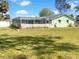 Large backyard featuring lush green grass and a charming screened-in porch. Great for Gathering gatherings at 523 Red Mangrove Ln, Apollo Beach, FL 33572