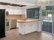 A well-lit kitchen featuring white cabinets, wood countertops and a window view of the pool at 523 Red Mangrove Ln, Apollo Beach, FL 33572