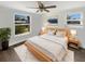 A cozy main bedroom with a ceiling fan, hardwood floors, two windows and a bright white rug at 523 Red Mangrove Ln, Apollo Beach, FL 33572