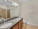 Bathroom with double sink vanity, granite countertop, and glass enclosed shower at 5485 Sunset Falls Dr, Apollo Beach, FL 33572