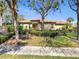 Charming single-story home featuring a clay tile roof and mature landscaping at 5485 Sunset Falls Dr, Apollo Beach, FL 33572