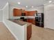 Kitchen with granite counters, wooden cabinets, and black appliances at 5485 Sunset Falls Dr, Apollo Beach, FL 33572