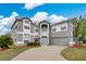 Two-story gray home featuring a two-car garage, blue front door, and curved driveway at 10809 Sailbrooke Dr, Riverview, FL 33579