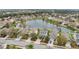 A picturesque aerial view of homes surrounding a tranquil pond in a well-maintained community at 15121 Searobbin Dr, Lakewood Ranch, FL 34202