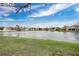 Scenic view of the tranquil pond with lush greenery and neighborhood homes in the distance at 15121 Searobbin Dr, Lakewood Ranch, FL 34202