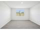 Bedroom features a large window that lets in plenty of light and soft gray carpet at 31610 Malbec Dr, Brooksville, FL 34602