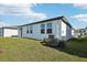 Spacious backyard with a white exterior, windows, and a lush green lawn at 31632 Malbec Dr, Brooksville, FL 34602