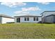 Expansive backyard featuring a white exterior, windows, and a sprawling lawn at 31632 Malbec Dr, Brooksville, FL 34602