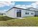 Backyard featuring a sliding glass door, windows, and a well-maintained lawn at 31632 Malbec Dr, Brooksville, FL 34602