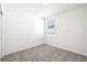 This bedroom features neutral carpet, white walls, and a window with blinds at 31632 Malbec Dr, Brooksville, FL 34602