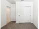 Bright bedroom featuring plush carpet, a closet, and a doorway to another room, offering comfort and convenience at 31632 Malbec Dr, Brooksville, FL 34602