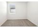 This is a bedroom featuring neutral carpet, white walls, and a window with blinds at 31632 Malbec Dr, Brooksville, FL 34602