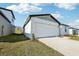 New home exterior with a white garage door, front door, and a well-manicured lawn at 31632 Malbec Dr, Brooksville, FL 34602