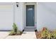 Exterior shot of a home featuring a teal front door, landscaped yard, and an attached white garage at 31632 Malbec Dr, Brooksville, FL 34602