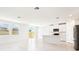 Open living space with tile floors, white kitchen, stainless steel appliances, and sliding glass doors at 31632 Malbec Dr, Brooksville, FL 34602