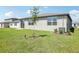 New home backyard with sliding glass door, a small patio, a lawn area, and a shade tree at 31668 Wild Grape Ln, Brooksville, FL 34602