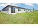New home backyard with sliding glass door, a small patio, and a lawn area at 31668 Wild Grape Ln, Brooksville, FL 34602