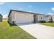 Exterior view of this single-story home featuring a two car garage and well maintained lawn at 31668 Wild Grape Ln, Brooksville, FL 34602