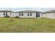 Exterior view of a house with a well-maintained lawn, a small tree, and an AC unit at 31681 Wild Grape Ln, Brooksville, FL 34602