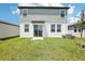 View of the home's rear elevation showing the patio and sliding glass door leading out to a spacious lawn at 3553 Moscato Dr, Brooksville, FL 34602