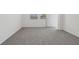 A carpeted bedroom with white walls, baseboards, two windows and a closet door at 3634 Moscato Dr, Brooksville, FL 34602